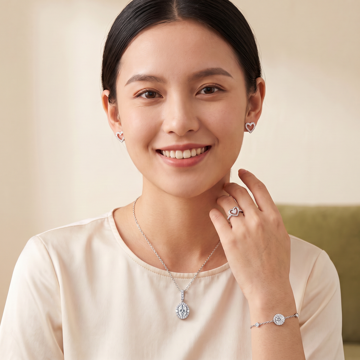 Model wearing the Celestia oval halo moissanite necklace, Hiba open-heart moissanite studs, Layla double heart moissanite ring and Yara moissanite halo bracelet in 925 sterling silver