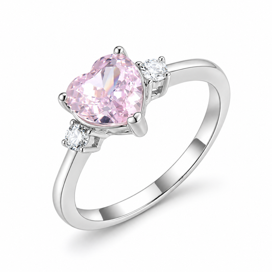 Blush pink heart CZ three-stone ring close-up: 7 mm pink heart CZ between two round white CZ, 925 sterling silver, Dubai